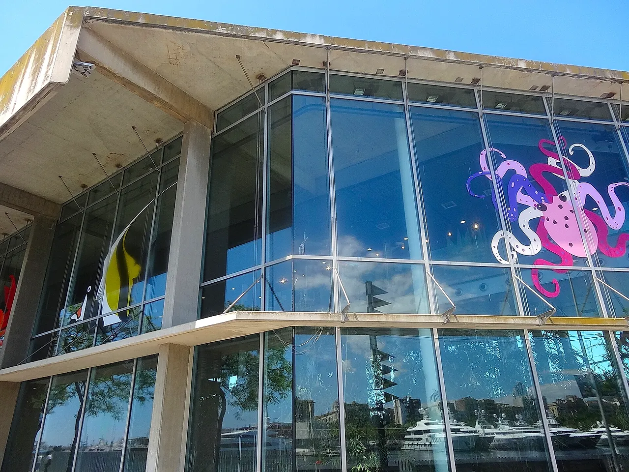 Glass facade of the Aquàrium de Barcelona on the Moll d'Espanya, with a colourful octopus design on the windows