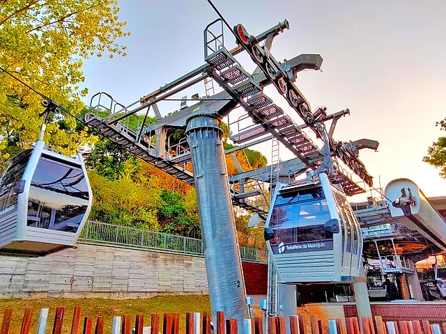 White cable car cabins waiting at the lower station of the Montjuïc cable car