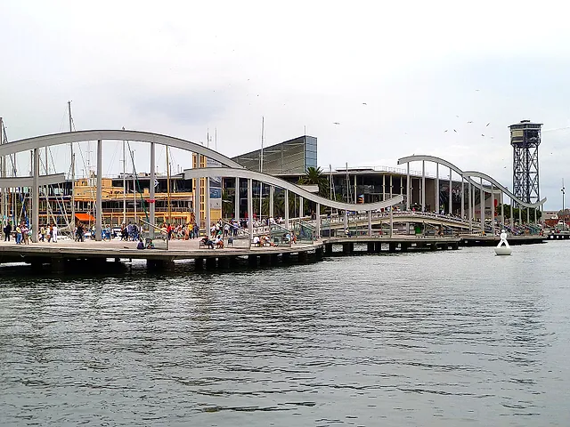 La passerella ondulata di legno della Rambla de Mar sul Port Vell, con il Maremagnum e la torre della funivia sullo sfondo